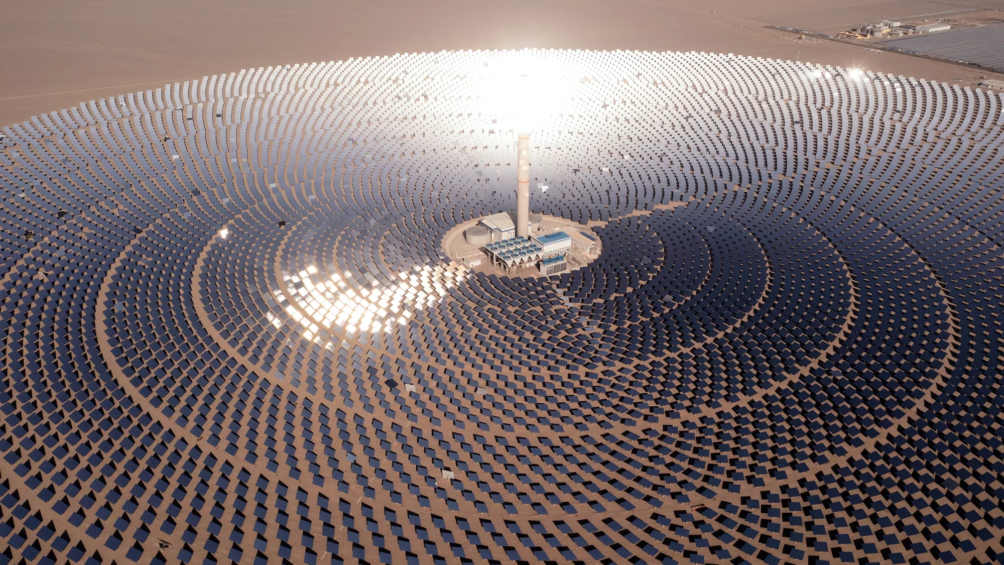 Une centrale solaire à concentration avec une tour contenant des sels liquides chauffés par un cercle d'héliostats. 
